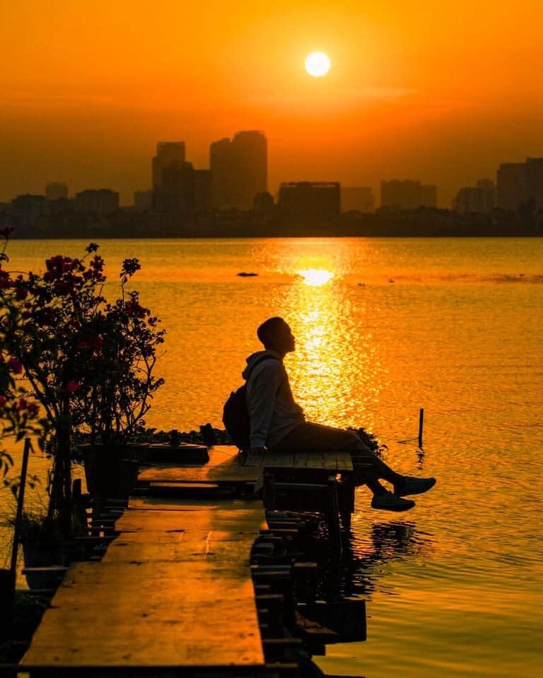 Tạo dáng chụp ảnh hoàng hôn thư giãn bên bờ hồ