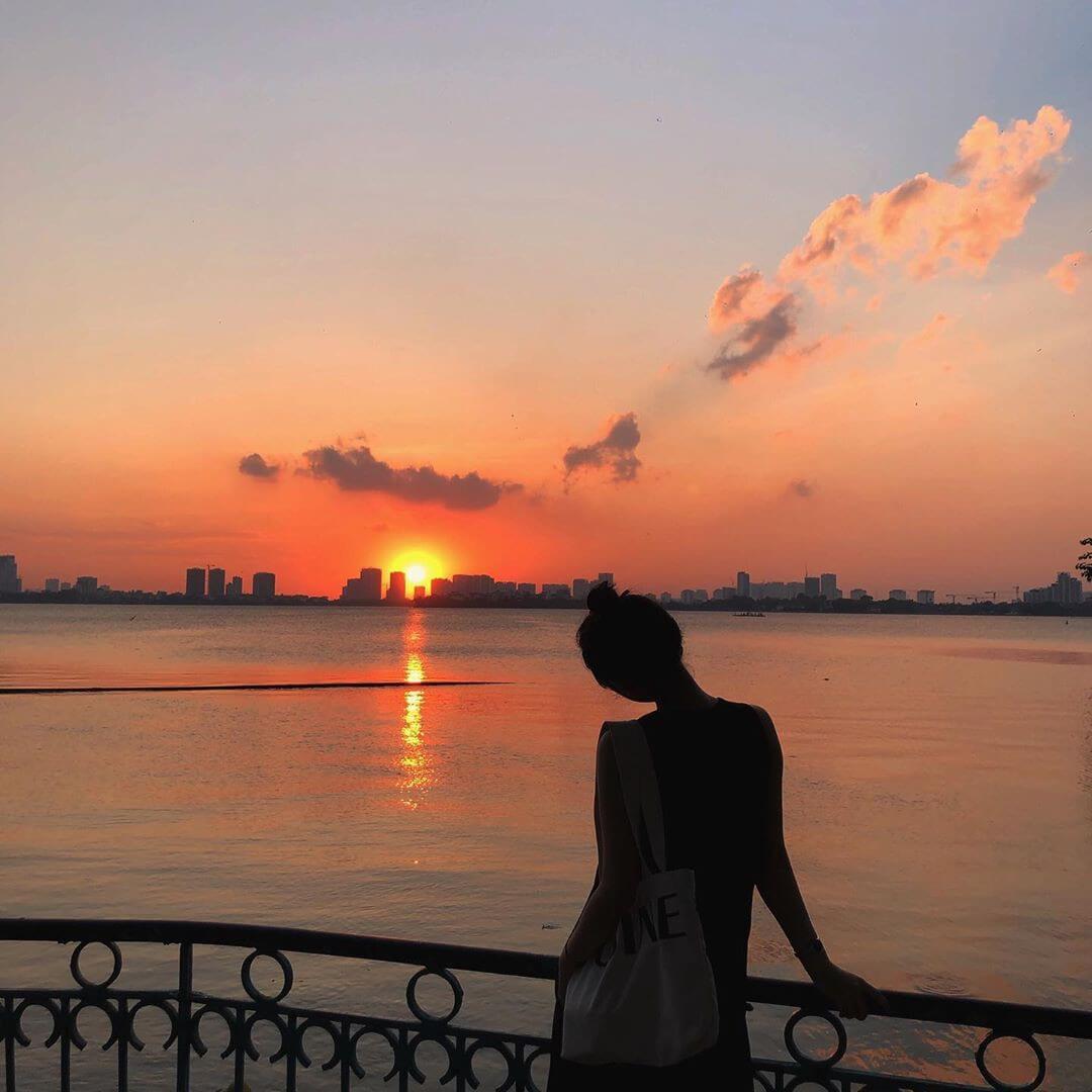 Tạo dáng chụp ảnh hoàng hôn ngay bờ sông