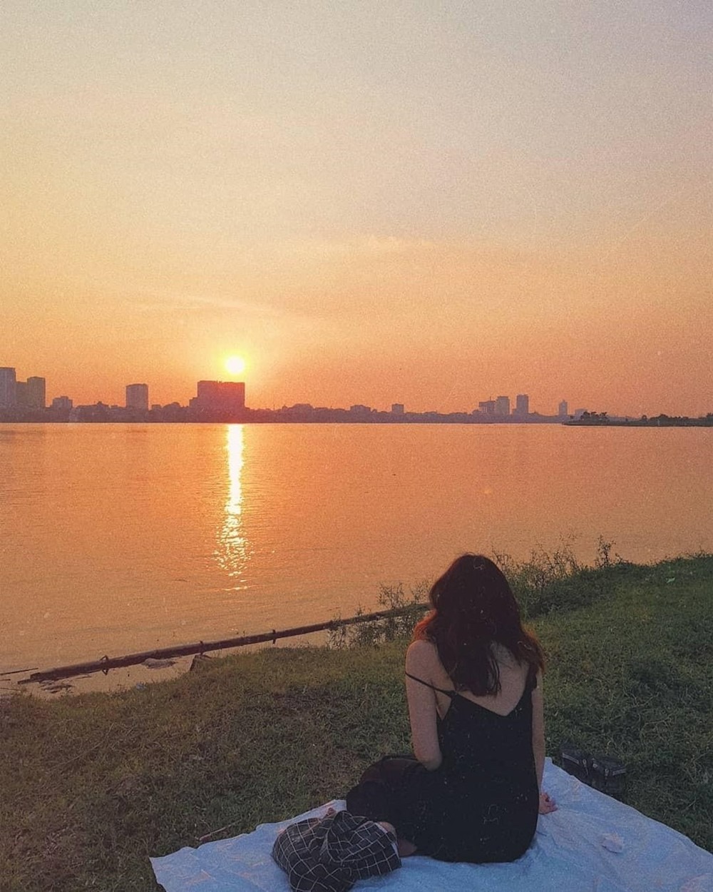 Tạo dáng chụp ảnh hoàng hôn trên bãi cỏ
